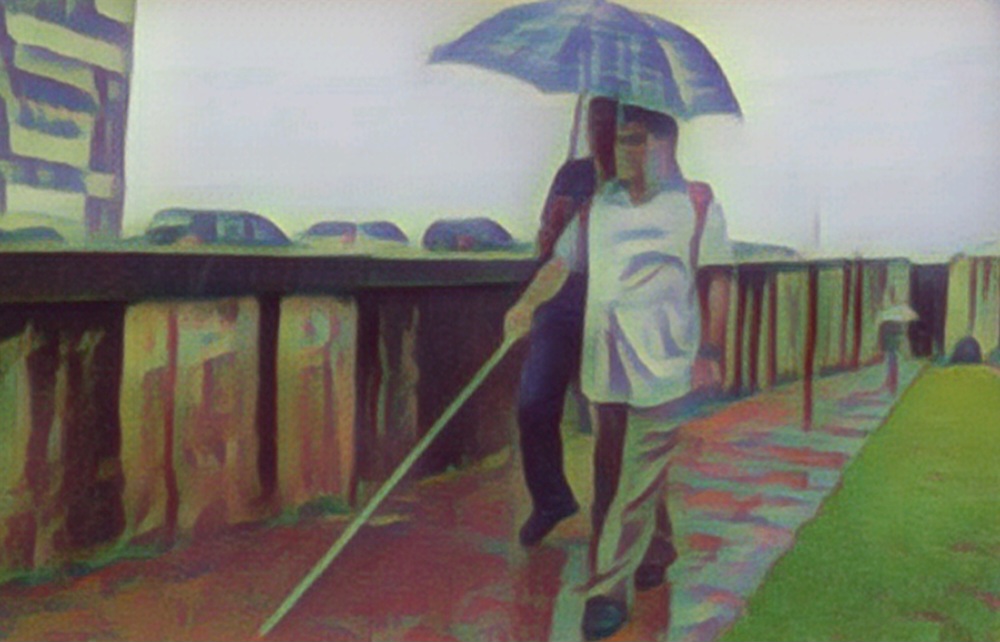 Imagem mostra 02 homens andando na chuva. Um esta segurando um guarda-chuva e o outro está com uma bengala longa